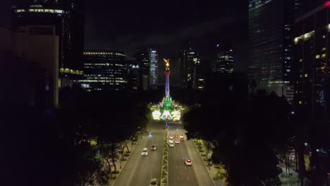 Vista-Aérea-De-La-Avenida-Reforma-Y-El-ángel-De-La-Independencia,-Iluminada-Con-Los-Colores-De-La-Bandera-Mexicana-En-La-Noche-Nacional-En-La-Ciudad-De-México