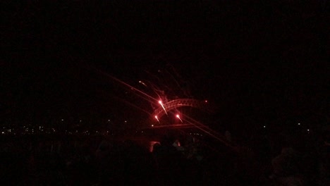 Spectators-watch-colourful-fireworks-exploding-on-Silver-Jubilee-bridge,-Widnes