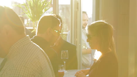 Man-and-woman-laugh-over-drinks-at-a-social-event