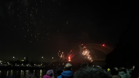 Multitud-Ver-Coloridos-Fuegos-Artificiales-Explotando-En-El-Puente-Del-Jubileo-De-Plata,-Ancho-En-La-Noche