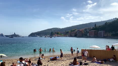 Tourists-Enjoying-Summer-At-Plage-des-Bains-In-Villefranche-sur-Mer,-France