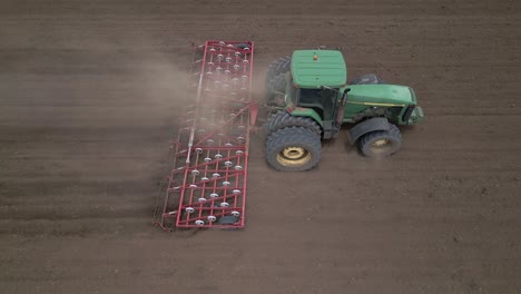 Dry-agricultural-field-is-prepared-for-seeding-by-tractor-and-harrow