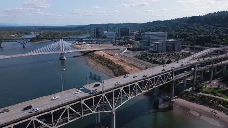 Drohnenaufnahme-Von-Downtown-Portland-Oregon-Waterfront-Bridges-Mit-Vorbeifahrenden-Autos