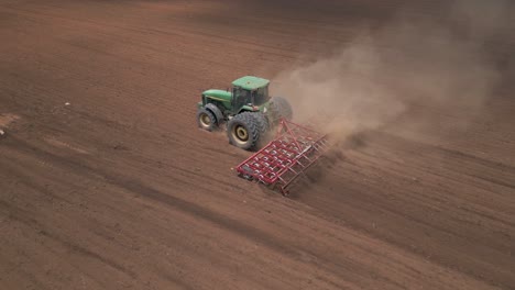 Trabajo-Polvoriento-Mientras-El-Tractor-Agrícola-Tira-De-La-Grada-De-Dientes-En-El-Campo-Antes-De-Plantar