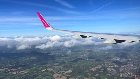 Timelapse-of-plane-flying-through-clouds-in-sky-with-wing-out-window