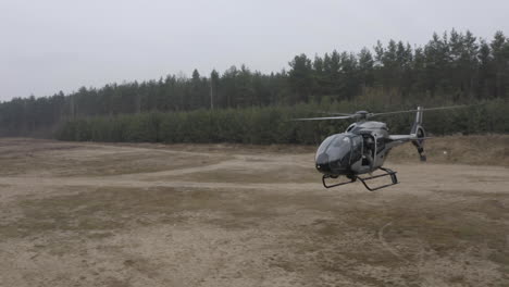 Aerial-View-of-Military-Helicopter-Flying-Above-Training-Field,-Drone-Shot