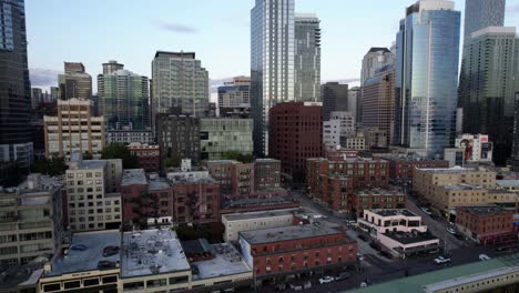 Aerial-view-rising-in-front-of-high-rise-in-downtown-Seattle,-dusk-in-Washington,-USA---Ascending,-drone-shot