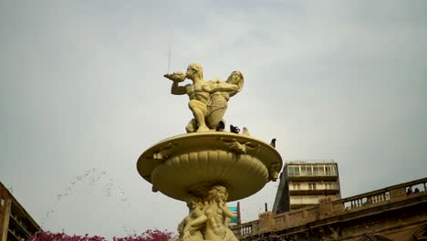 Cámara-Lenta,-Vista-Manual-En-ángulo-Bajo-De-Una-Paloma-Aterrizando-En-La-Fuente-De-Las-Utopías-En-Rosario,-Argentina