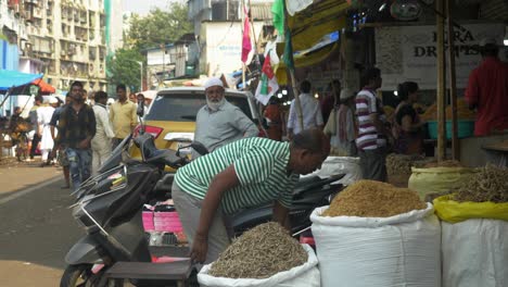 Static-shot-of-a-man-cleaning-his-shop-area-and-people-buying-dry-fish-from-oldest-and-largest-dry-fish-wholesale-market-of-Wadala,-Mumbai