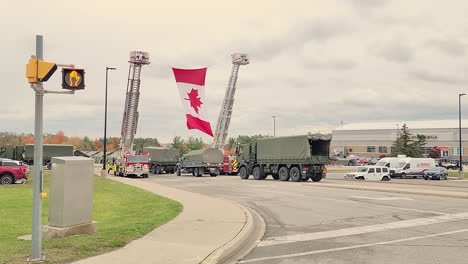 Kanadische-Flagge,-Die-Von-Zwei-Feuerwehrautos-Während-Des-Trauerzugs-Für-Zwei-In-Innisfil-Getötete-Polizisten-Gehisst-Wurde