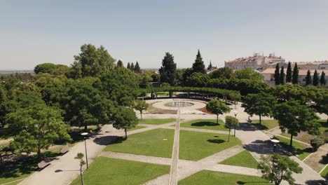 Aerial-backwards-view-of-elegant-public-garden-with-fountain