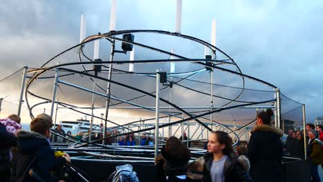 Public-interact-with-glowing-spiral-light-looper-neuron-touch-artwork,-Liverpool-pier-head-river-of-light-event