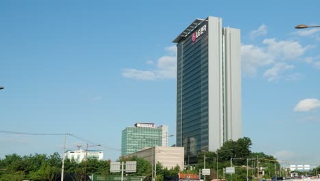 Yangjae-daero-Road-Complex-Tráfico-De-Vehículos-Pesados-Y-Vista-Del-Edificio-Del-Campus-De-Investigación-Y-Desarrollo-De-Lg-Electronics-Seocho-En-Un-Día-Nublado---Acercar