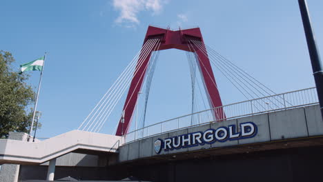 Slowmotion-Kippaufnahme-Der-Willemsbrücke-Von-Unten-Mit-Wehender-Fahne