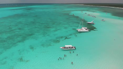 Gente-De-Vacaciones-Nadando-En-El-Mar-Caribe-Tropical-Entre-Yates-De-Lujo,-El-Cielo-Cozumel-Mexico