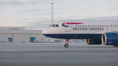 British-Airways-Airbus-A320-Neo-taxiing-on-Reykjavik-airport-tarmac,-tracking-cockpit