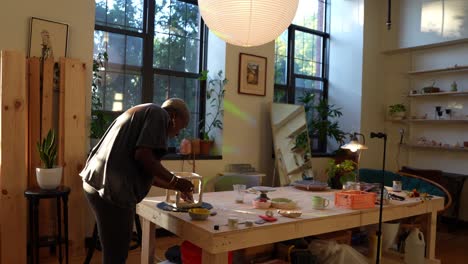 4k-60fps---An-african-american-artist-sculpting-a-clay-box-in-her-studio-during-golden-hour