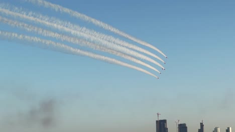 Nahaufnahme-Der-Kunstflugstaffel-Mit-Den-Roten-Pfeilen-Und-Der-Skyline-Von-Kuwait-Im-Hintergrund