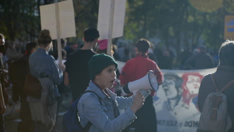 Una-Joven-Entusiasta-Habla-Con-Enojo-Con-Un-Megáfono-Durante-Una-Protesta-Antidisturbios