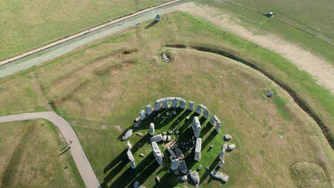 Luftaufnahme-über-Den-Steinkreis-Von-Stonehenge-Und-Erdarbeiten,-Die-In-Die-Flache-Landschaft-Von-Salisbury-Fliesen