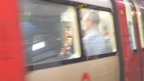 Passengers-On-The-Platform-At-London-Underground-With-Train-Arriving-In-London,-UK