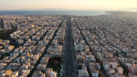 City-center-of-Athens-skyline,-residential-buildings-and-seascape,-aerial-view-at-sunrise-time