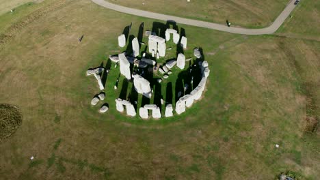 Stonehenge-ancient-stone-trilithon-circle-o-Salisbury-plain,-Aerial-view-pull-back-tilt-up