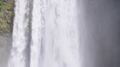 Tourist,-Der-Vor-Mächtigem-Skogafoss-wasserfall-In-Island-Steht