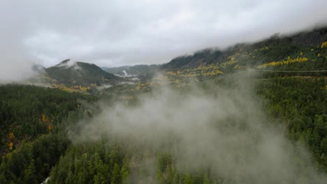 Fliegen-Durch-Wolken-über-Wald-In-Richtung-Berge-Im-Nördlichen-Klima-Von-Oben,-Britisch-Columbia-Kanada