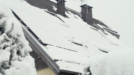 Solar-panels-of-private-home-covered-in-pure-white-snow,-motion-view