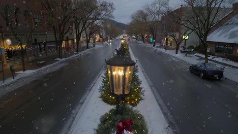 Cinematic-aerial-rising-shot-of-Christmas-wreath-on-lamp-post-in-Wellsboro-PA