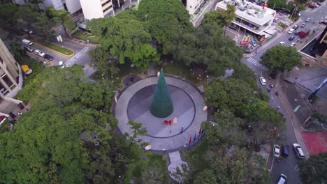 Drohne-Fliegt-über-Die-Plaza-Isabel-La-Católica-In-La-Castellana-Und-Kippt-Dann-Nach-Caracas,-Venezuela