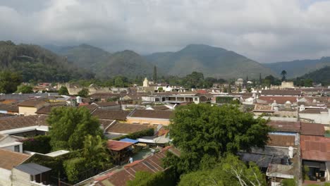 Flying-low-over-rooftops-of-Antigua-city,-sunny-day-in-Guatemala---Aerial-view