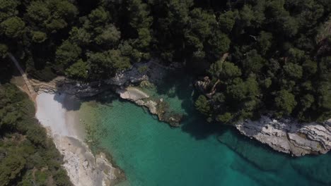 Drone-shot-of-a-cliffy-coastline-in-Croatia---drone-is-ascending-in-vertical-view,-facing-a-little-bay