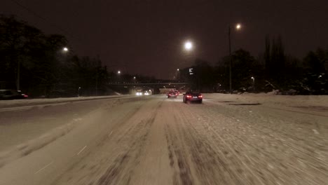 POV-shot-driving-through-downtown-Helsinki-with-pedestrians-walking-across-crossings-at-night