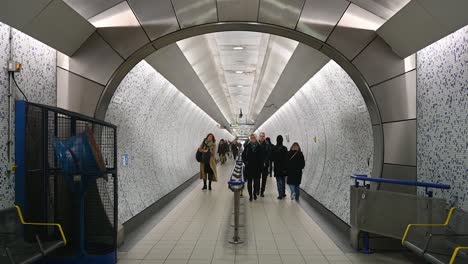 Passengers-Walking-Through-The-Centre-Of-Green-Park-Station,-London,-United-Kingdom
