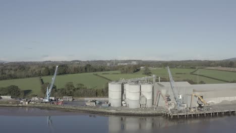 Aerial-of-silos,-cranes,-and-pier-facility-of-riverside-cement-plant