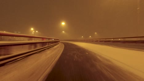 POV-shot-driving-over-and-under-snowy-bridges-in-Helsinki,-Finland