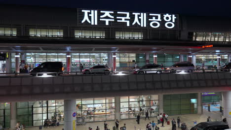 Nachtansicht-Des-Internationalen-Flughafens-Jeju-Mit-Autos,-Die-In-Der-Stadt-Jeju,-Südkorea,-Fahren