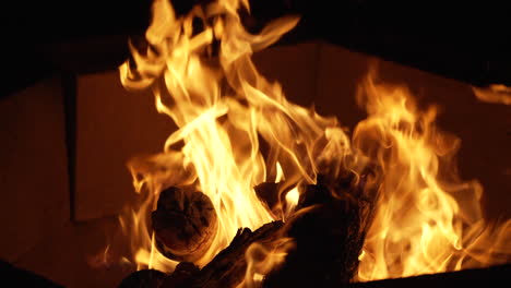 Live,-hot-flames-curl-out-of-the-fire-pit-in-the-cold-of-the-night---slow-motion