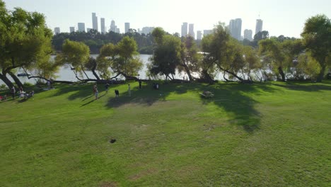 Push-in-reveal-over-kids-playing-soccer-to-yarkon-park-lake-full-of-paddle-boats-with-families-#017