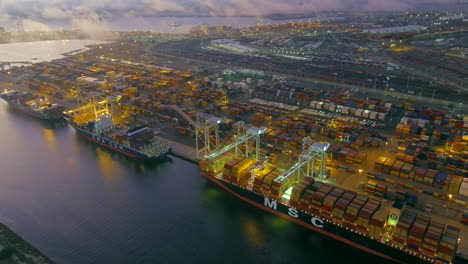 Oakland-Port-Containerschiffe-Entladen-Fracht-Beleuchtet-Bei-Nacht-Luftbild-Steigt-Zurück
