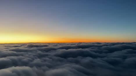 Blick-Auf-Den-Sonnenuntergang-Aus-Einem-Jet-Cockpit,-Das-Wolken-Mit-Einem-Orangefarbenen-Horizont-überfliegt