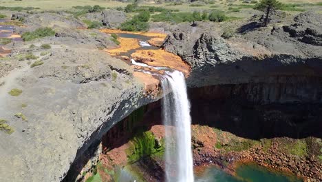 Schöne-Aussicht-Auf-Einen-Wasserfall-Mit-Felsen-Gemischt-Mit-Orange-Und-Blau,-Im-Sonnenlicht