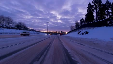 POV-shot-driving-along-a-freshly-gritted-snowy-highway-in-Helsinki