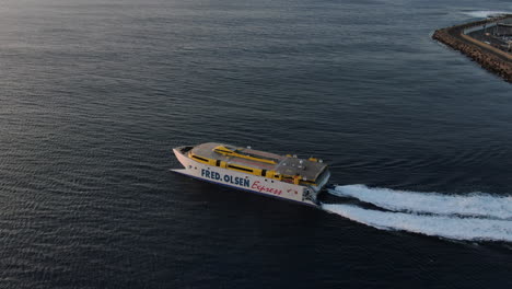 Fantástica-Toma-Aérea-De-Un-Ferry-Que-Sale-Del-Puerto-De-Agaete-Hacia-Tenerife-Durante-La-Puesta-De-Sol