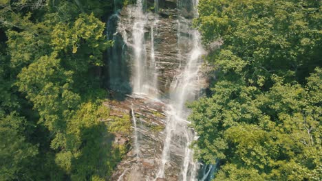 Epic-reveal-of-Amicalola-Falls,-an-enormous-waterfall-towering-over-the-area-at-729-feet-tall,-the-largest-in-all-of-Georgia