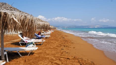 Touristen,-Die-Sich-Auf-Sonnenliegen-An-Einem-Sandstrand-Von-Megas-Lakkos-In-Griechenland-Entspannen---Statische-Aufnahme