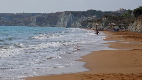 Tourists-Lounging-By-The-Megas-Lakkos-Beach-In-Kefalonia-Greece---wide-shot