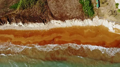 Ocean-Waves-Splashing-On-Red-Sand-Shore-Of-Megas-Lakkos-Beach-In-Greece---aerial-top-down